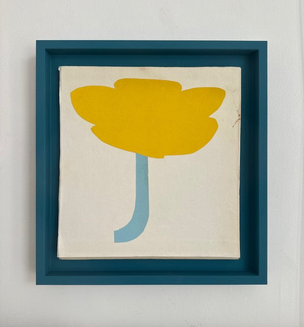 A framed paper collage artwork featuring a yellow flower with a blue stem on a white background, titled 'Buttercup' by Lauri Hopkins.