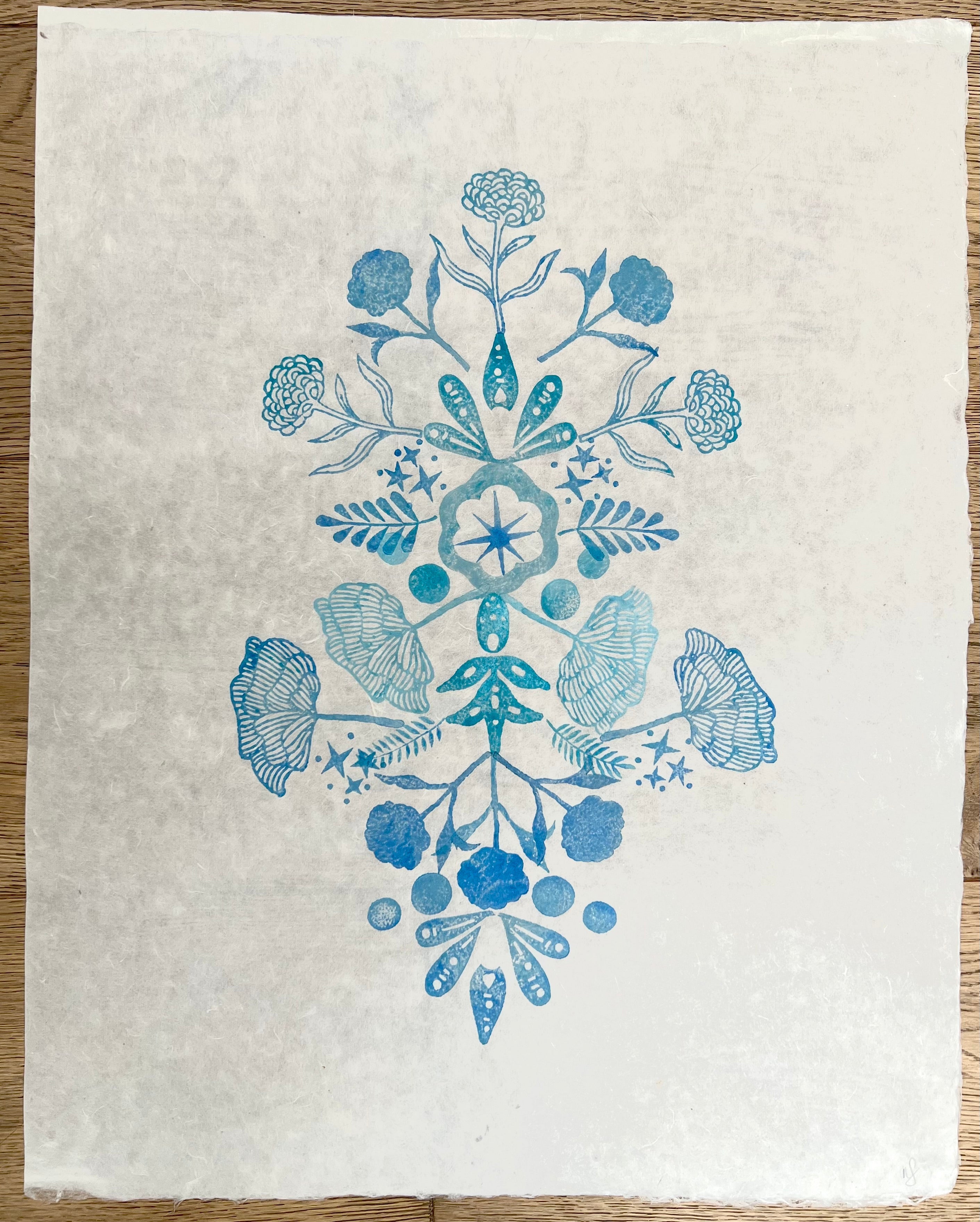 Little Garden 'Blue' by Neera Sehgal depicting white fabric with blue floral and leaf pattern on a wooden surface