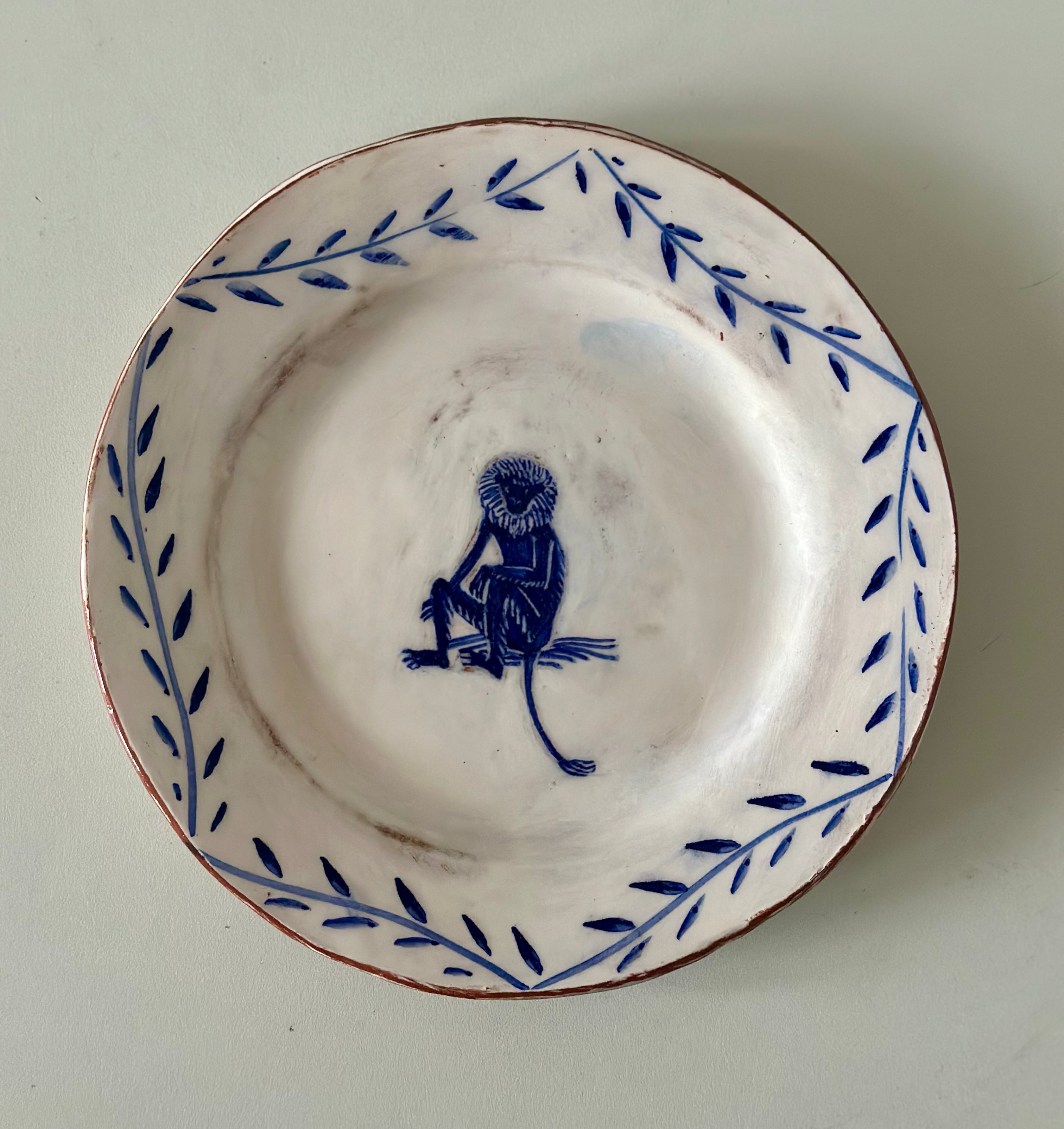 White ceramic plate with blue decorative border and central design on a white background
