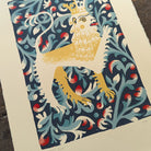 Lion by Tom Frost. Decorative print of a lion with a crown on a blue floral background.
