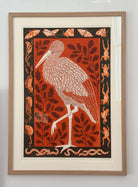 Balance by Lizzie Wheeler. Framed artwork of a heron with leafy patterns on an orange background