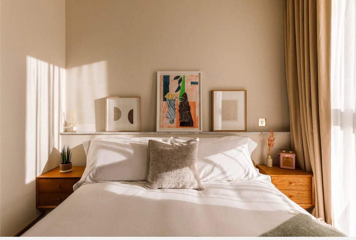 3 framed artworks on shelf behind bed at The Gessner London by art consultancy
