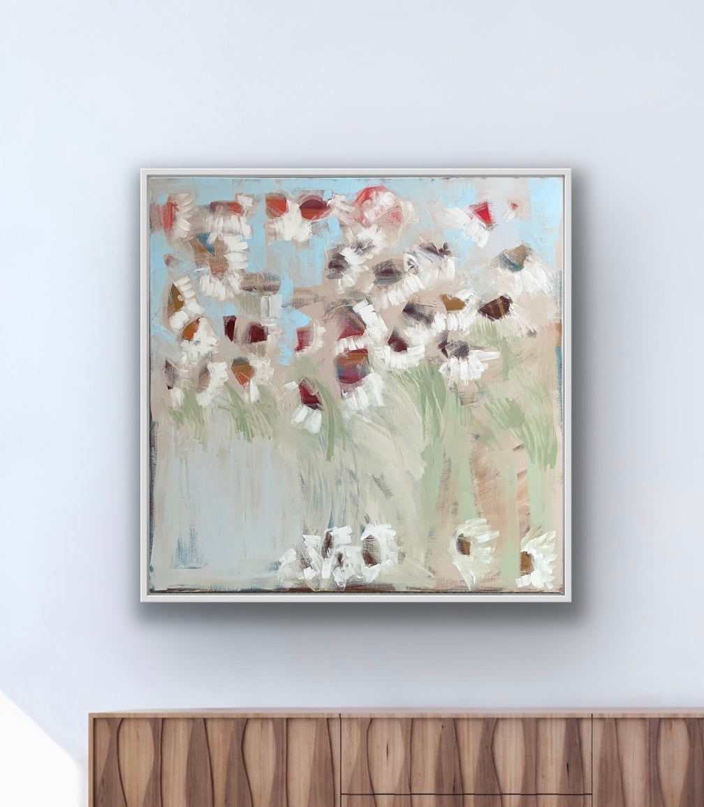 Evening Daisies by Claire Oxley hanging on a wall above a contemporary sideboard.