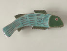 Ceramic fish-shaped object on a plain background