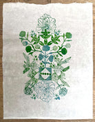 Little Garden 'Green' by Neera Sehgal depicting a white fabric with green floral embroidery on a wooden surface