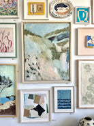 Saint, Sand & Sea by Samantha Rudd, hung on wall with various framed artworks and decorative items