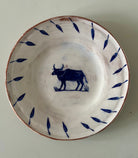 Ceramic plate with blue bull design on a white background