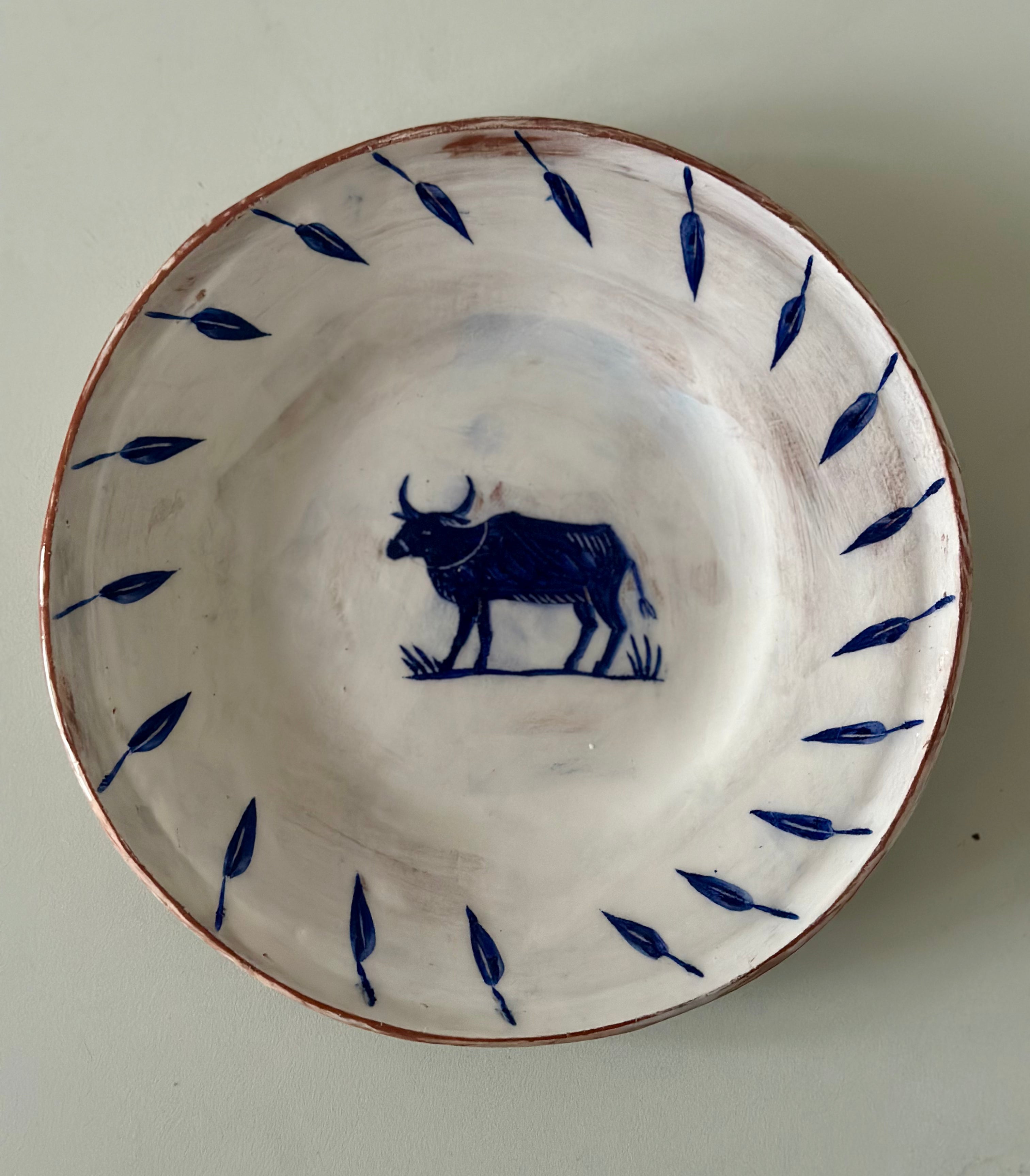 Ceramic plate with blue bull design on a white background