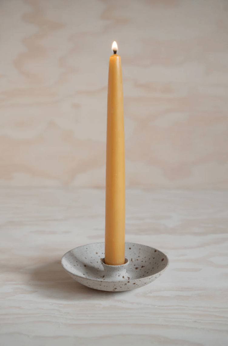 'Swallow' candlestick holder with orange candle by ceramicist Charlie Maw